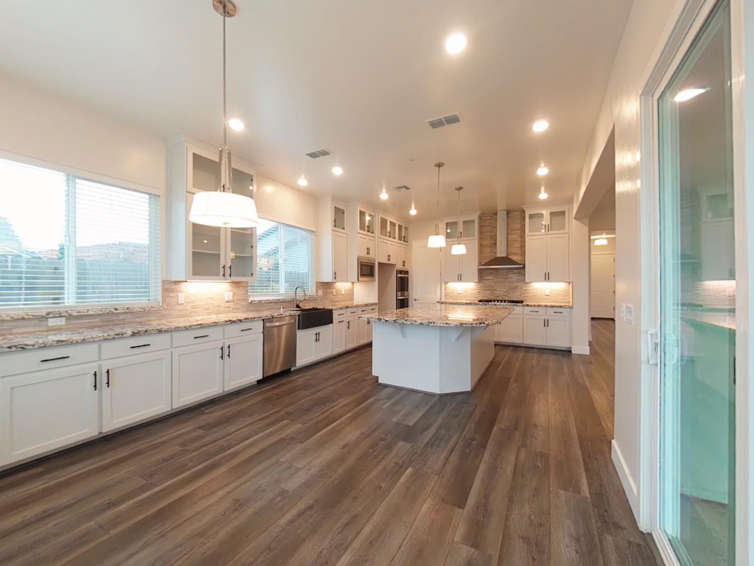 1236 Buck Ridge Rocklin, CA 95765 - Photo 16 of 66 a large kitchen with kitchen island a sink dishwasher a stove a dining table and chairs