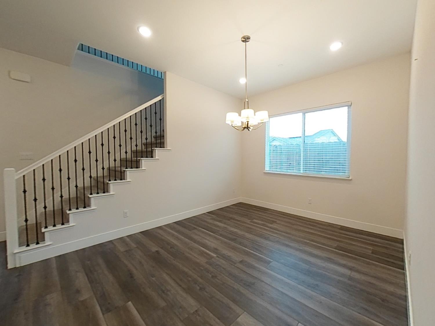 1236 Buck Ridge Rocklin, CA 95765 - Photo 6 of 66 an empty room with wooden floor windows and stairs