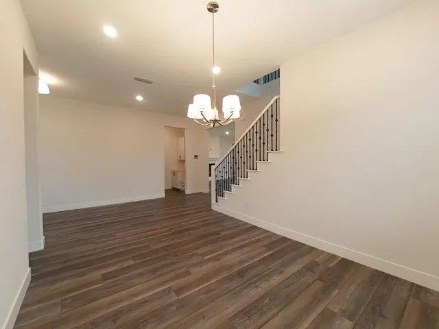 a large kitchen with granite countertop a large counter top a sink stainless steel appliances and cabinets