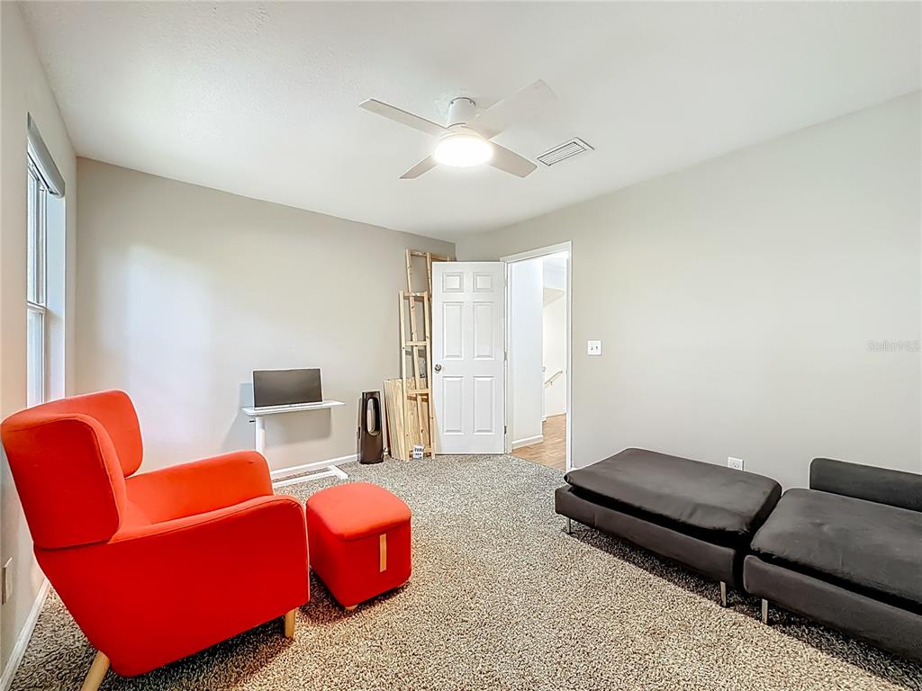 6380 Bahaia Road Fleming Island, FL 32003 - Photo 32 of 77 a living room with furniture a couch and a ceiling fan