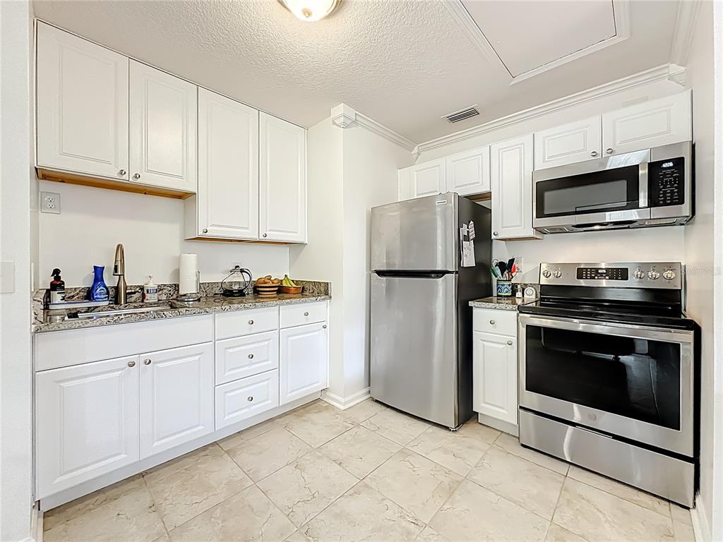 6380 Bahaia Road Fleming Island, FL 32003 - Photo 47 of 77 a kitchen with stainless steel appliances granite countertop a refrigerator stove a sink and a microwave