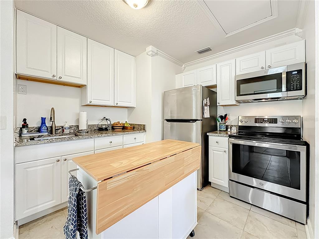 6380 Bahaia Road Fleming Island, FL 32003 - Photo 48 of 77 a kitchen with stainless steel appliances granite countertop a refrigerator stove a sink and a microwave