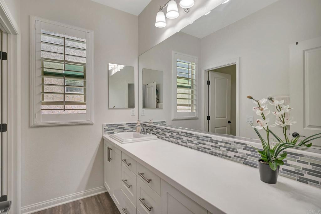 21408 Trail Ridge Drive Escondido, CA 92029 - Photo 22 of 50 a bathroom with a granite countertop sink a large mirror a and a window