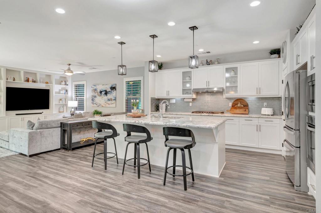 21408 Trail Ridge Drive Escondido, CA 92029 - Photo 6 of 50 a kitchen with stainless steel appliances granite countertop a table chairs refrigerator and microwave