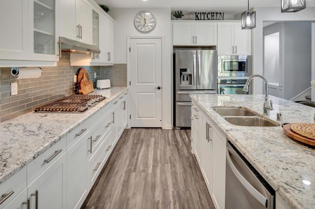 21408 Trail Ridge Drive Escondido, CA 92029 - Photo 7 of 50 a kitchen with granite countertop a sink stove refrigerator and cabinets