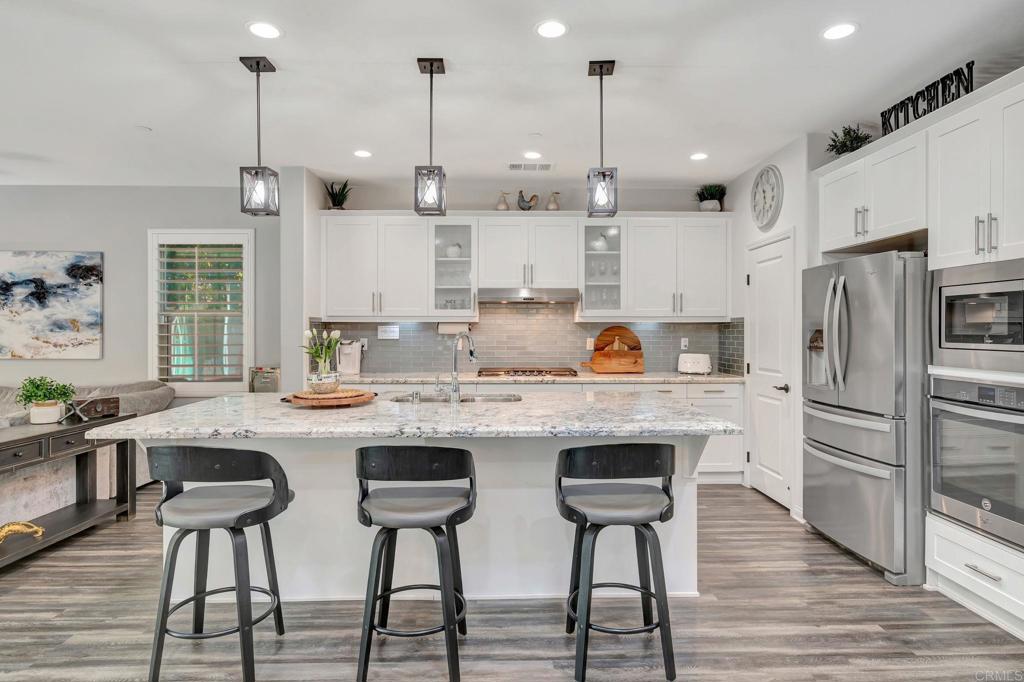 21408 Trail Ridge Drive Escondido, CA 92029 - Photo 10 of 50 a kitchen with stainless steel appliances granite countertop a table chairs stove and refrigerator