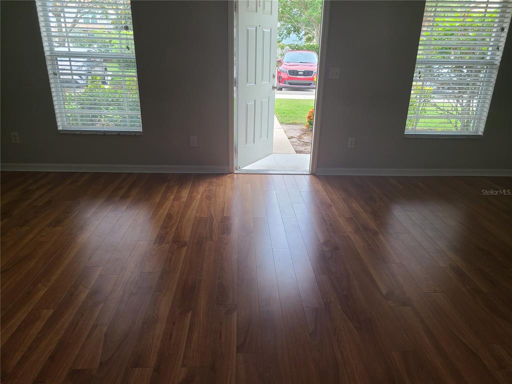 14956 Amberjack Terrace, Unit 103 Lakewood Ranch, FL 34202 - Photo 6 of 16 an empty room with wooden floor and windows