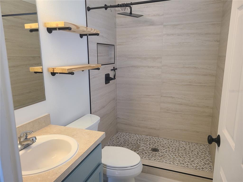 14956 Amberjack Terrace, Unit 103 Lakewood Ranch, FL 34202 - Photo 10 of 16 a bathroom with a sink a toilet and shower