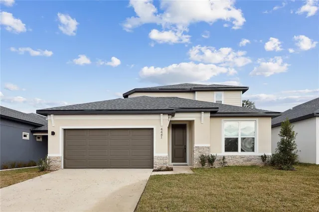 a front view of a house with yard and parking space