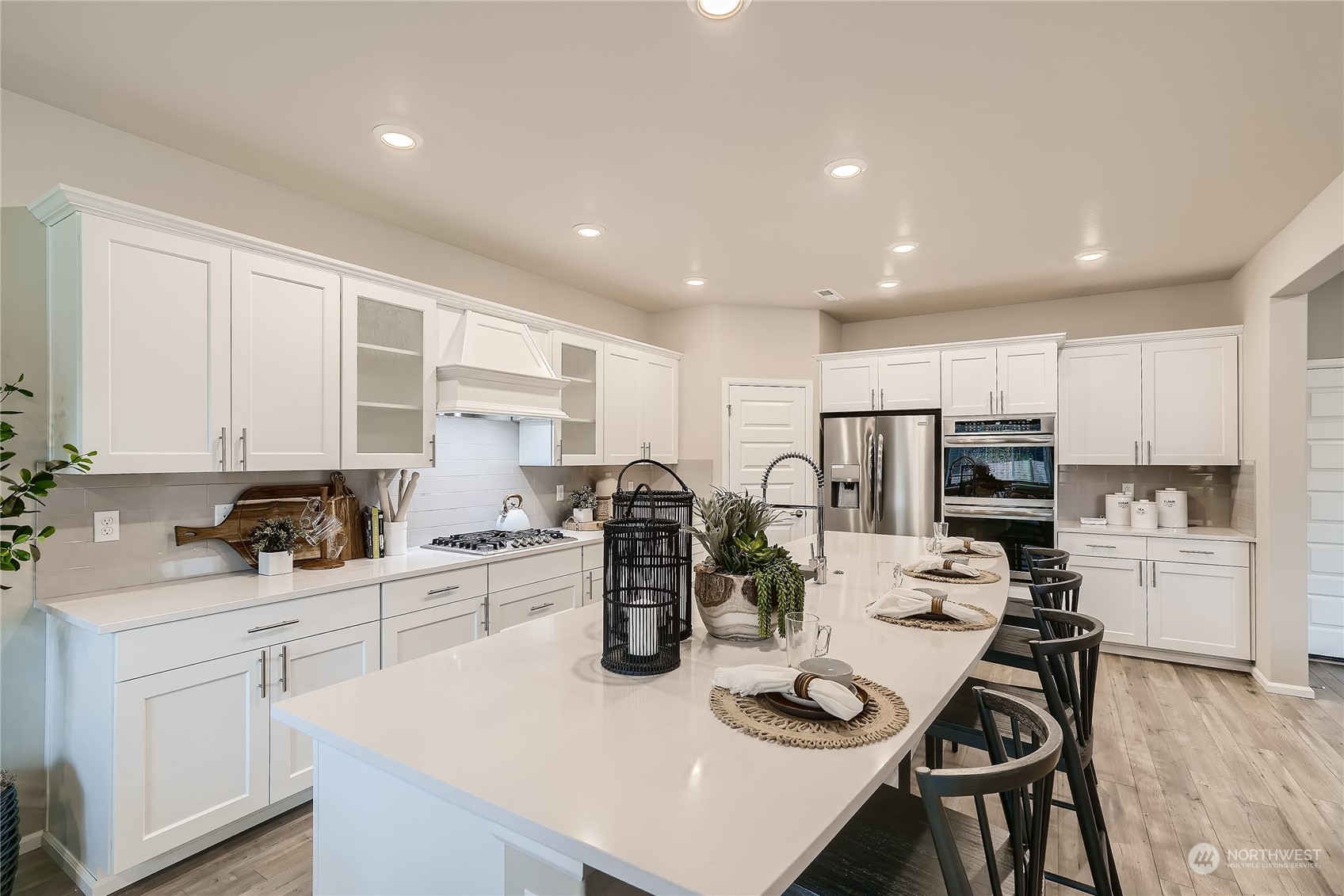 21120 42nd Drive Southeast, Unit 124 Bothell, WA 98021 - Photo 10 of 23 a kitchen with stainless steel appliances kitchen island granite countertop a sink dishwasher a stove a refrigerator with white cabinets and wooden floor