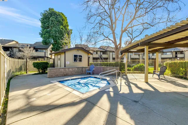 a view of a patio with a table and chairs under an umbrella