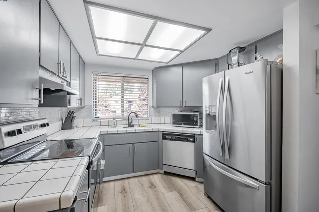 a kitchen with stainless steel appliances a refrigerator sink and microwave