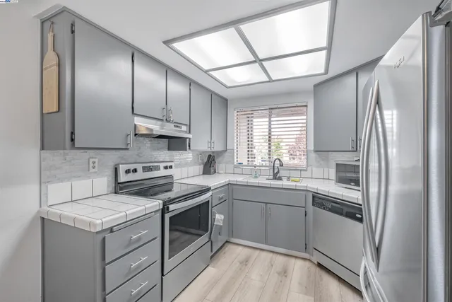 a kitchen with stainless steel appliances granite countertop a sink stove and refrigerator