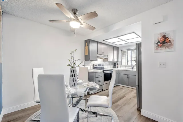 a view of a dining room with furniture and a chandelier fan