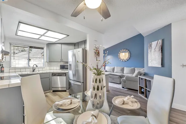 a living room with furniture kitchen view and a window