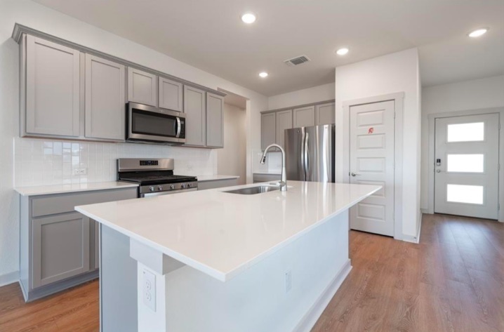 10805 Meris Lane Austin, TX 78754 - Photo 10 of 28 Culinary dreams come true in this modern kitchen, featuring a spacious island and top-tier appliances.