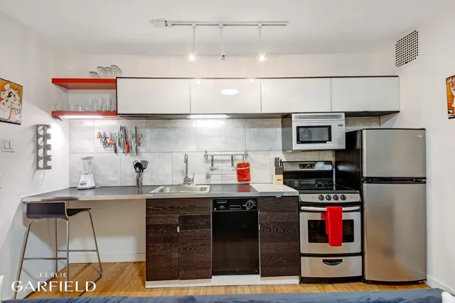a kitchen with stainless steel appliances granite countertop a refrigerator and a stove