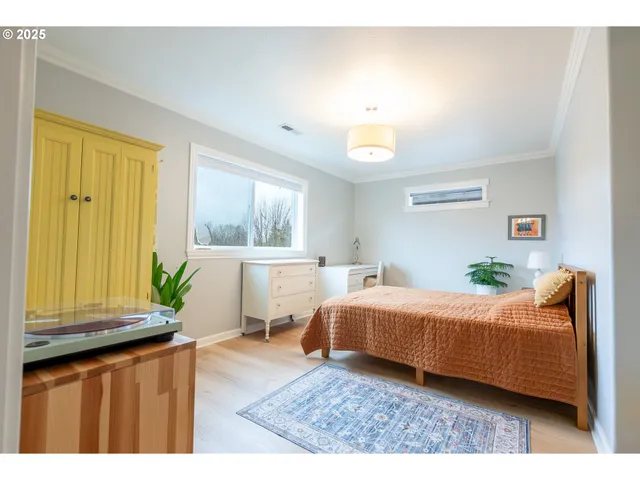 a bedroom with a bed and wooden floor