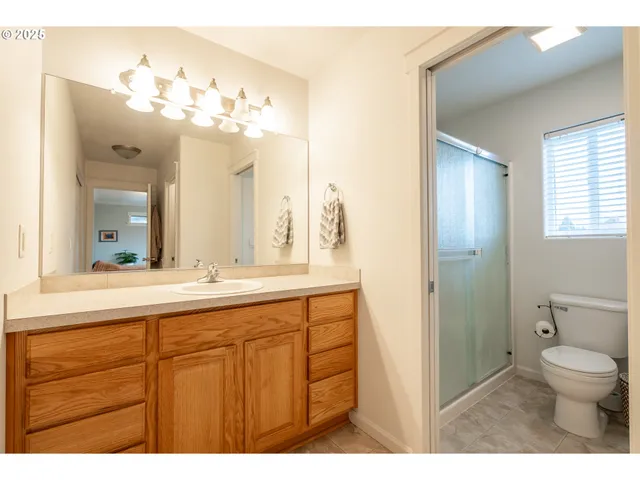 a bathroom with a granite countertop sink a toilet and a mirror