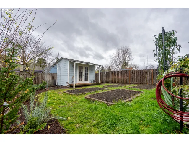 a view of backyard with wooden fence and large trees