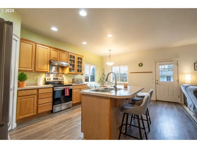 a kitchen with kitchen island granite countertop wooden floors and stainless steel appliances