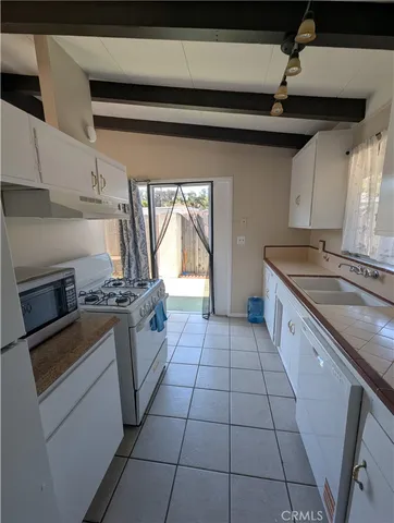 a kitchen with a stove top oven a sink and a cabinets