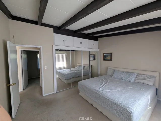 a bedroom with a bed and a refrigerator