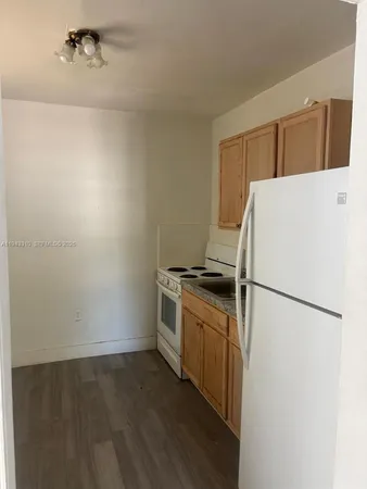 a white refrigerator freezer and a stove sitting inside of a kitchen
