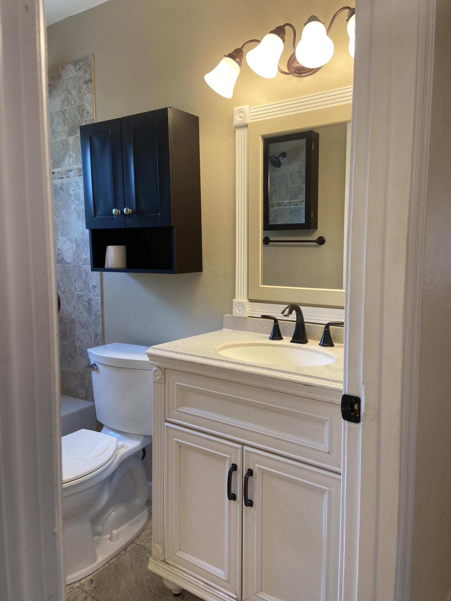 2544 Coventry Road Melbourne, FL 32935 - Photo 7 of 16 a bathroom with a toilet a sink and mirror
