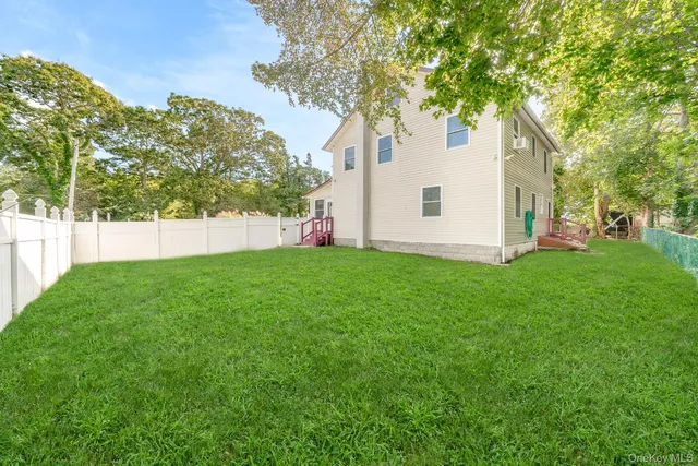 a view of a backyard with plants and large trees