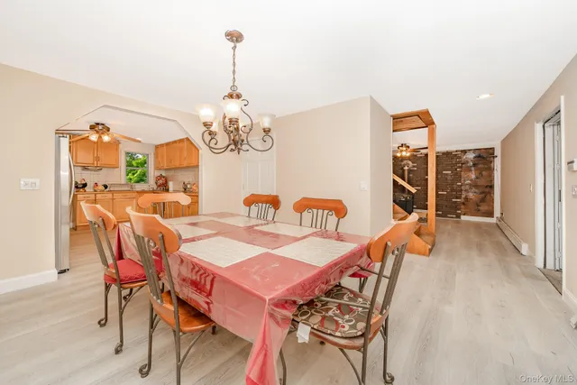 a dining room with furniture a chandelier and wooden floor