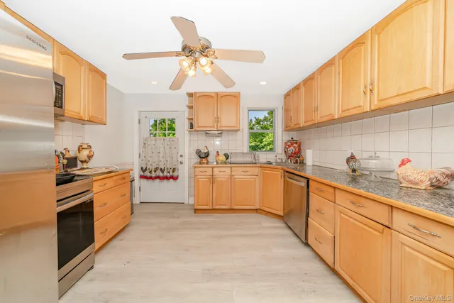 a large kitchen with stainless steel appliances granite countertop a sink and cabinets