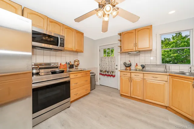 a kitchen with stainless steel appliances granite countertop a stove sink microwave and window