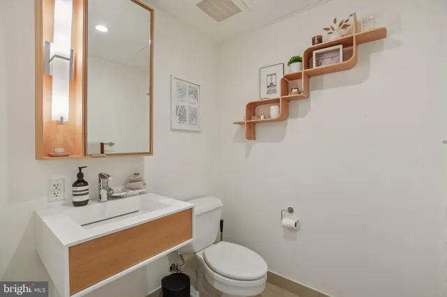 a bathroom with a sink toilet and mirror