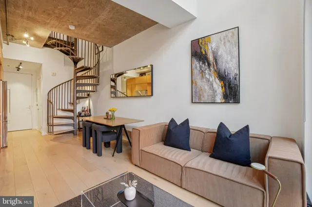 a living room with furniture and a painting on the wall