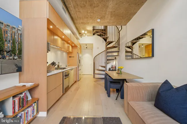 a living room with couches a dining table and chairs with wooden floor