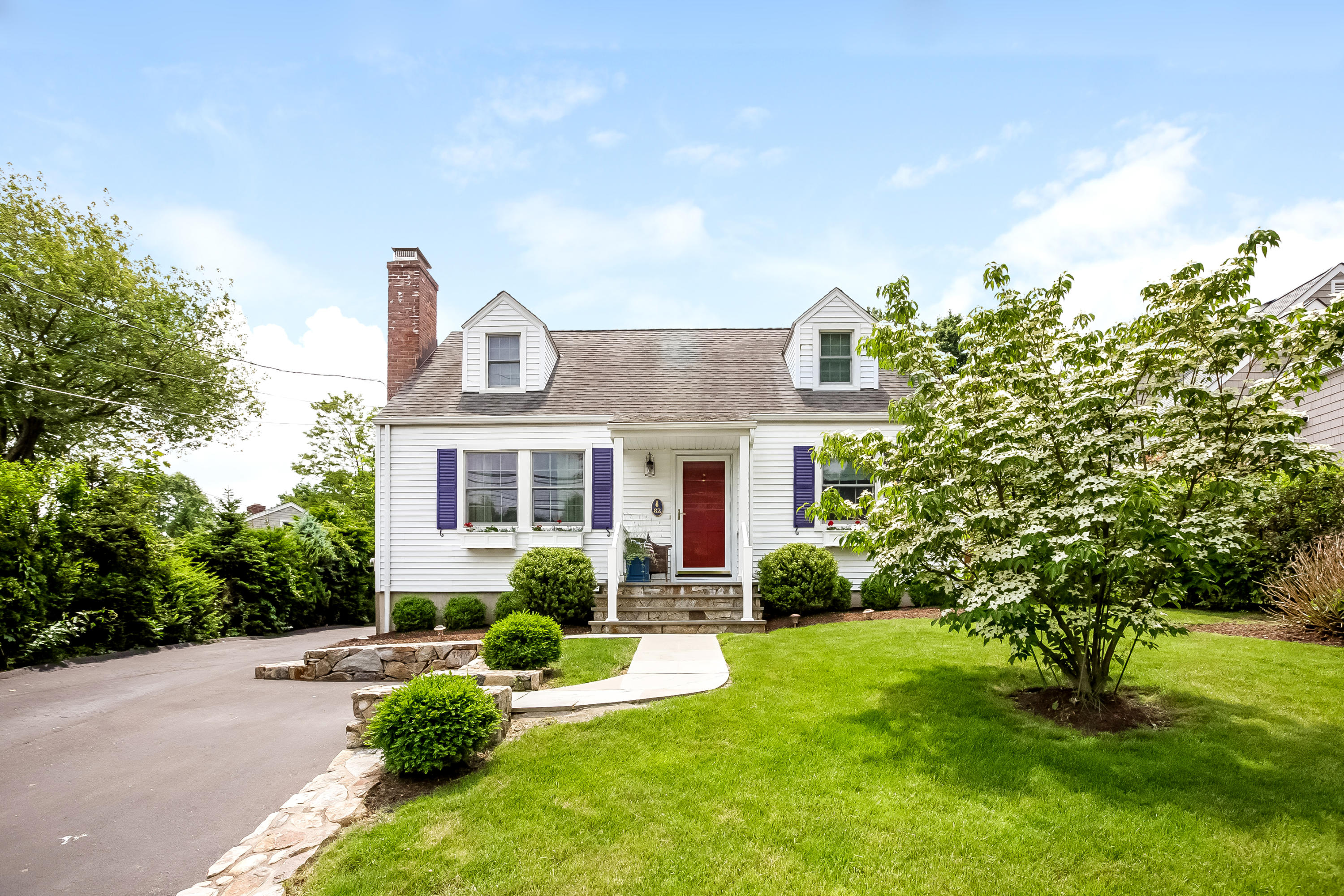 a front view of a house with a yard and potted plants