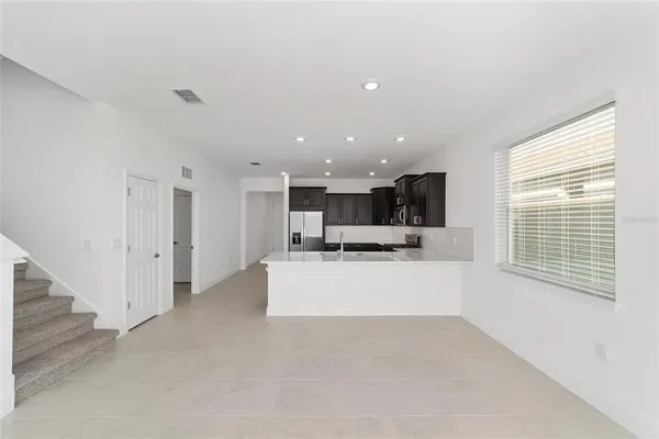 a view of kitchen with stainless steel appliances kitchen island sink refrigerator and window