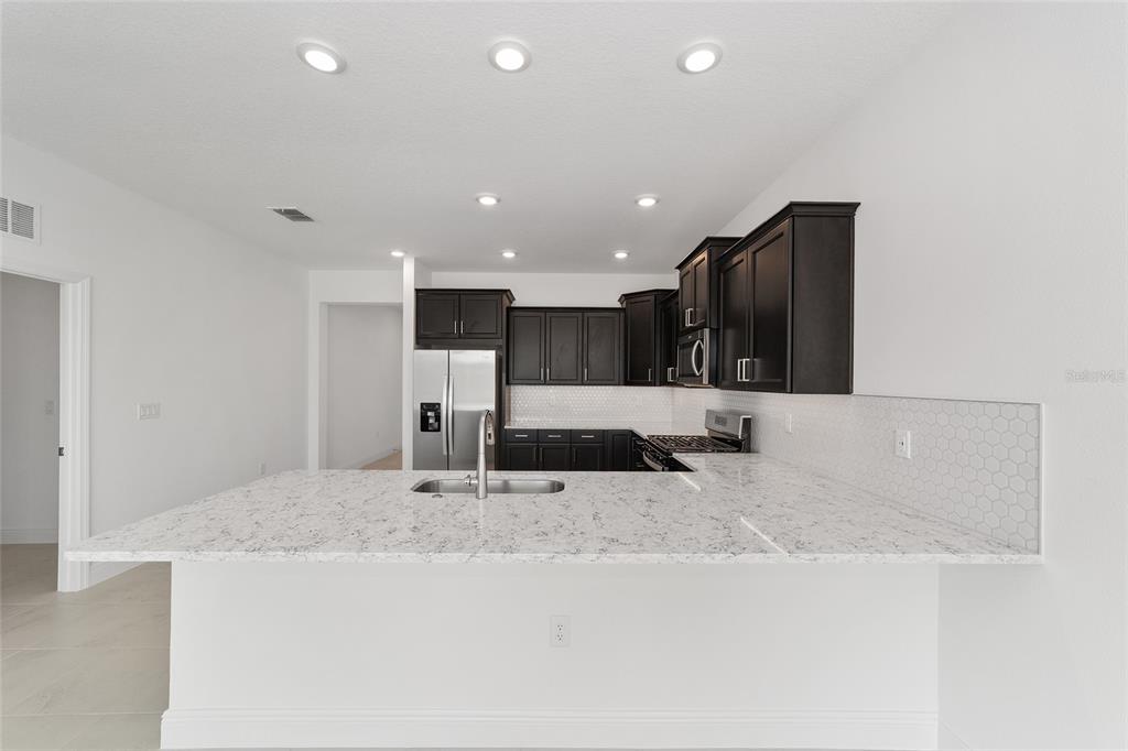 7276 Southwest 58th Place Road Ocala, FL 34474 - Photo 18 of 44 a kitchen with stainless steel appliances granite countertop a sink and a refrigerator