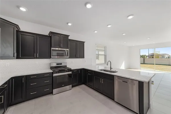 a kitchen with granite countertop a sink and stainless steel appliances