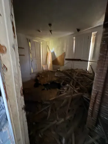 a view of a livingroom with wooden floor and a fireplace
