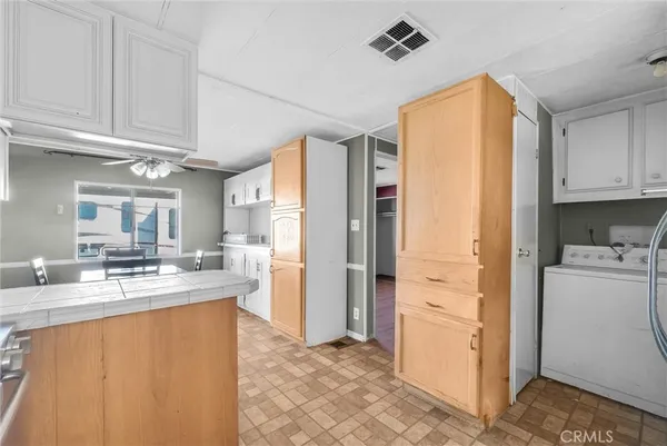 a kitchen with stainless steel appliances granite countertop a refrigerator a sink and white cabinets