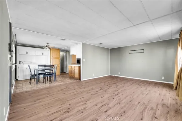 a view of empty room with wooden floor and seating space