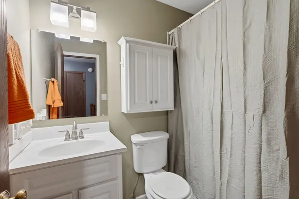 a bathroom with a toilet a sink and a mirror