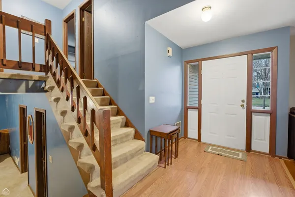 a view of an entryway with wooden floor and stairs