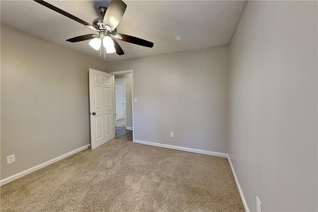 40 Arbor Way Dallas, GA 30157 - Photo 12 of 22 an empty room with a chandelier fan and a ceiling fan