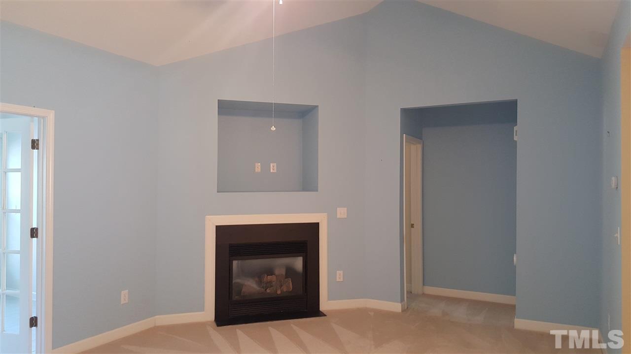 2513 Forest Shadows Lane Raleigh, NC 27614 - Photo 14 of 24 a room with a fireplace and a table