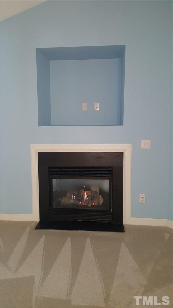 2513 Forest Shadows Lane Raleigh, NC 27614 - Photo 15 of 24 a fireplace with a clock in it