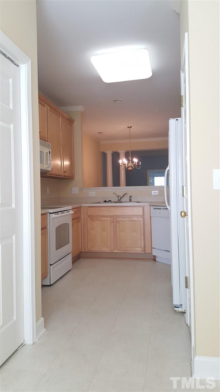 2513 Forest Shadows Lane Raleigh, NC 27614 - Photo 4 of 24 a kitchen with white cabinets and white appliances