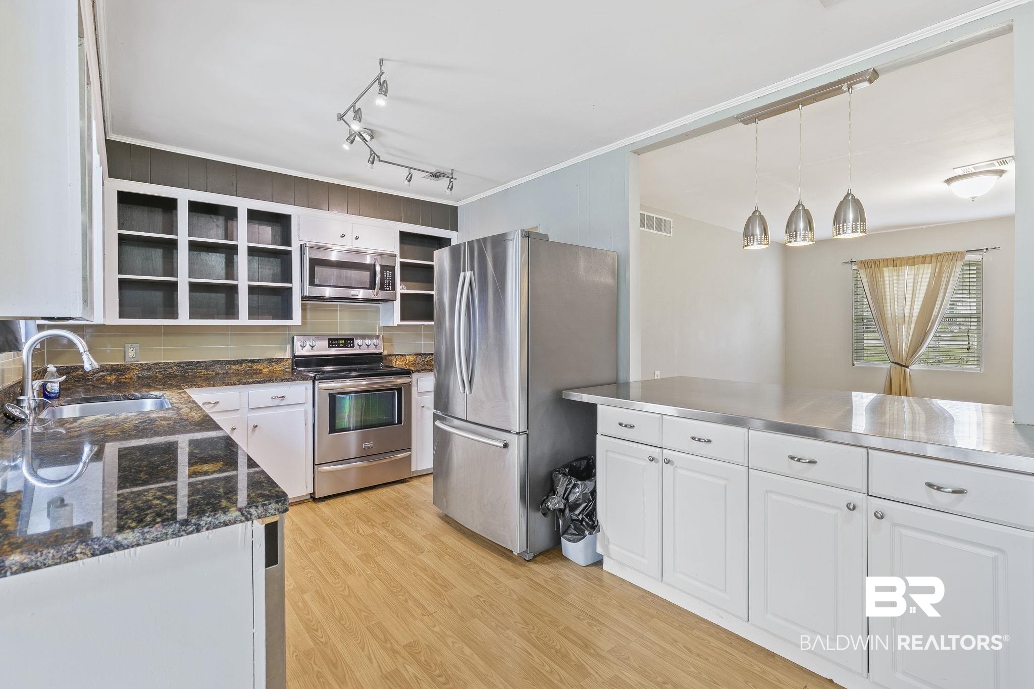 13108 6th Street Lillian, AL 36549 - Photo 11 of 39 Kitchen featuring sink, light wood-type flooring, stainless steel appliances, pendant lighting, and white cabinets